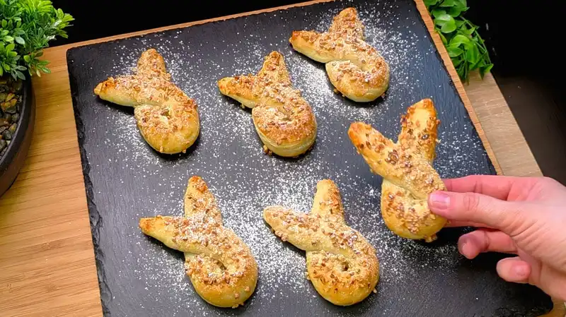 Goldbraun gebackene Nutella-Hasen aus Blätterteig mit gehackten Haselnüssen und Puderzucker