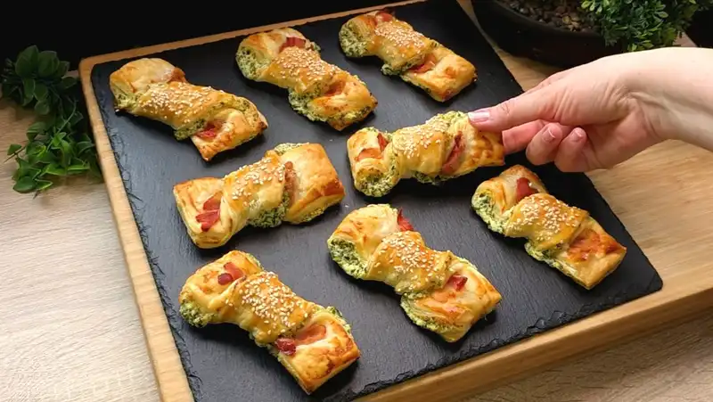 Goldbraun gebackene, gedrehte Blätterteig-Stangen mit Bärlauch, knusprigem Speck und Sesam.