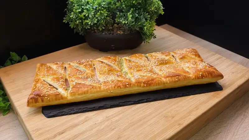 Goldbraun gebackene Blätterteig-Häppchen mit einer Füllung aus Bärlauch, Schinken und geschmolzenem Käse.