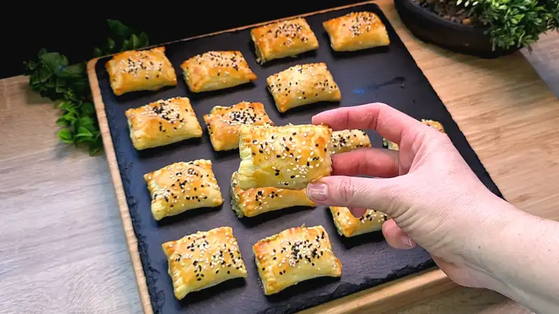 Nahaufnahme von goldbraun gebackenen Blätterteigtaschen gefüllt mit Bärlauchcreme