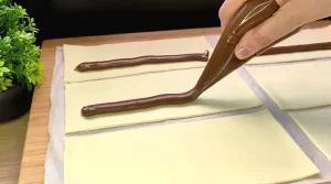 Blätterteig wird mit Nutella bestrichen