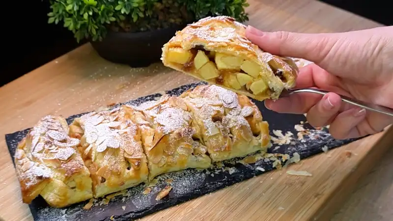 Detailansicht der saftigen Apfel-Zimt-Füllung mit Rosinen in einem aufgeschnittenen Strudel