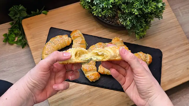 Detailansicht der cremigen Bärlauch-Käse-Füllung in einem aufgeschnittenen Blätterteig-Hörnchen