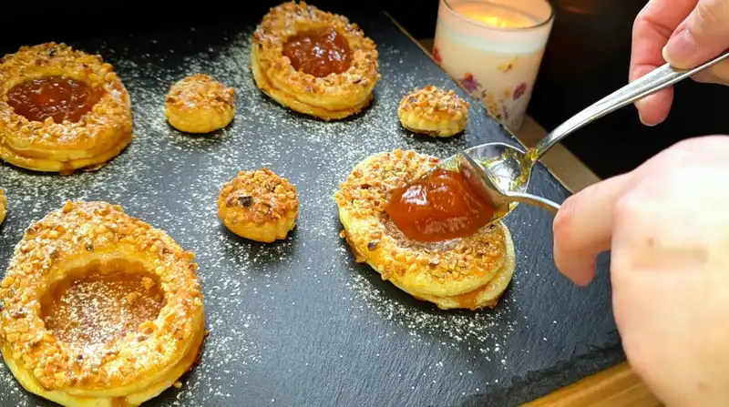 Detailansicht eines Osterei-Gebäcks aus Blätterteig mit Puderzucker und glänzender Aprikosenmarmelade