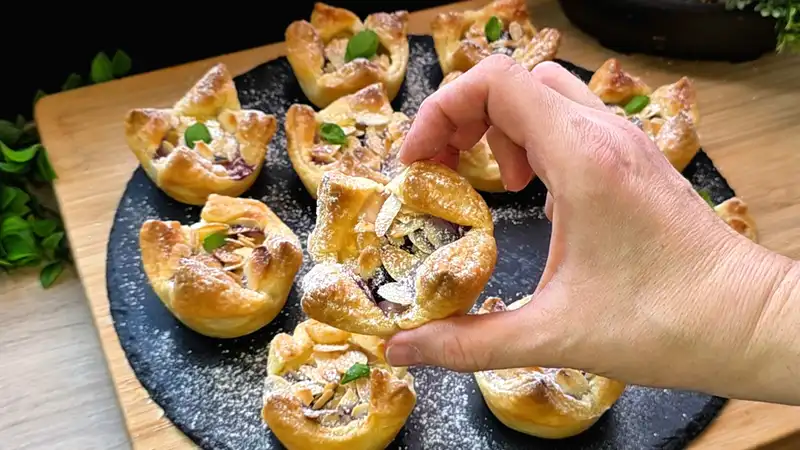 Detailansicht eines Blätterteig-Muffins mit cremiger Quarkfüllung, frischen Blaubeeren und Mandelsplittern