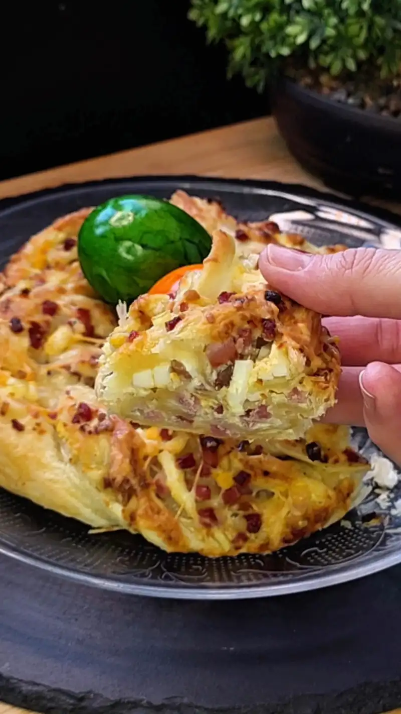 Detailansicht der saftigen Schinken-Ei-Käse-Füllung in den Schichten des Blätterteig-Kranzes