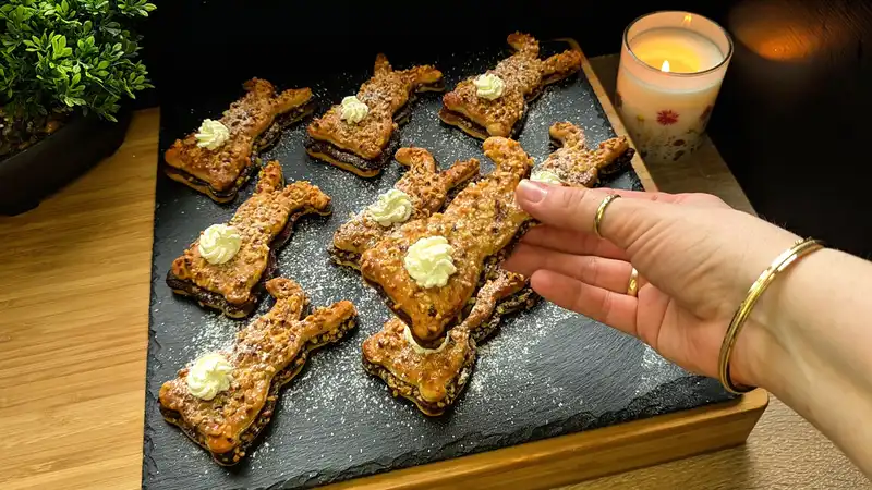 Detailansicht eines Nutella-Hasen aus Blätterteig mit Puderzucker und einem Tupfer Sahne als Schwanz.