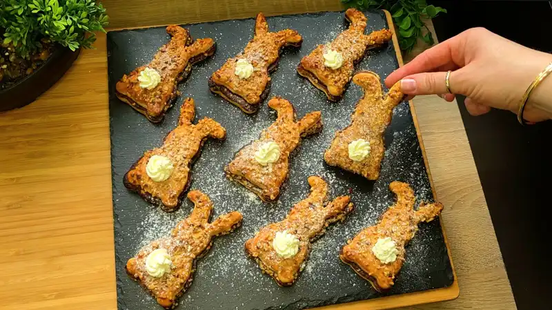 Gebackene Blätterteig-Osterhasen gefüllt mit Nutella und Haselnüssen, dekoriert mit Sahne-Tupfern