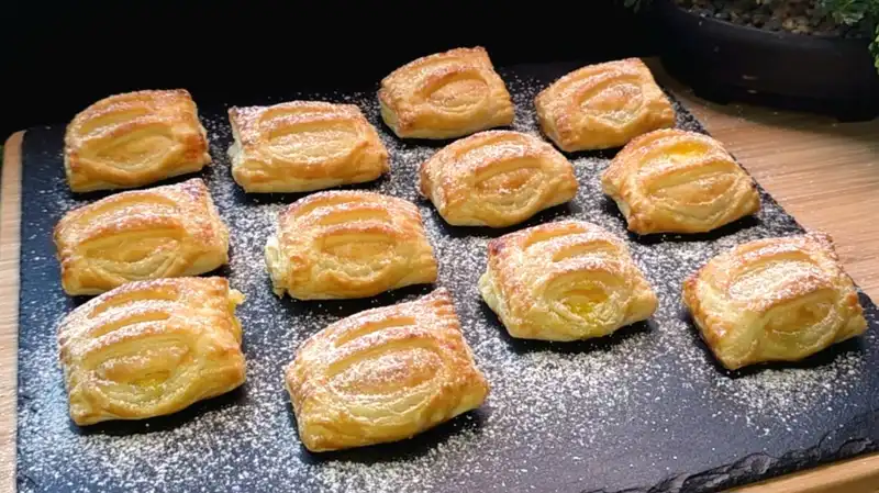 Wenn du Lust auf etwas Süßes hast, aber nicht stundenlang in der Küche stehen willst, sind diese Pudding-Bananen-Häppchen deine Rettung! In weniger als 30 Minuten Vorbereitungszeit zauberst du einen Snack, der geschmacklich locker mit jedem Teilchen vom Bäcker mithalten kann. Die Kombination aus warmem, samtigem Vanillepudding und der fruchtigen Süße der gebackenen Banane im Inneren des knusprigen Blätterteigs ist einfach unwiderstehlich. Durch kleine Einschnitte im Teig vor dem Backen entsteht nicht nur eine tolle Optik, sondern der Dampf kann auch perfekt entweichen. Diese kleinen Taschen sind ideal für den Kaffeeklatsch, als Überraschung für Kinder oder einfach als Seelenschmeichler zwischendurch. Niemand wird glauben, dass dieser Genuss so simpel in der Zubereitung ist!