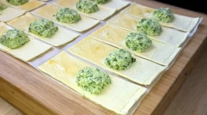 Bärlauch Käsecreme wird auf Blätterteigstücke gegeben