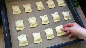 Rohe Bärlauch Blätterteig Taschen liegen auf dem Backblech vor dem Backen