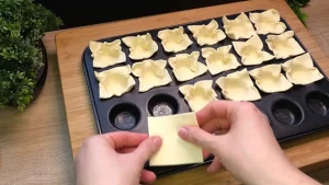 Blätterteig Quadrate werden in eine Backform gedrückt