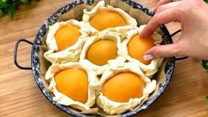 Die gefalteten Blätterteig-Päckchen werden eng nebeneinander in eine runde Backform gelegt