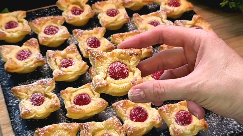 Nahaufnahme von cremigen Blätterteig Küchlein mit saftigen Himbeeren