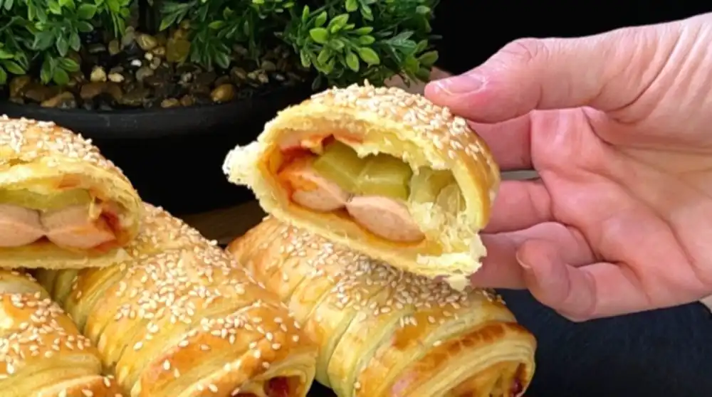 Nahaufnahme von saftigen Blätterteig Taschen mit Würstchen, Käse und knuspriger Kruste