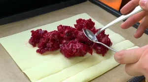 Die eingedickte Kirschmasse wird auf eine Hälfte der Blätterteigplatte gegeben