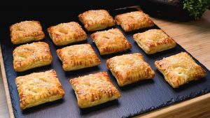 Goldbraun gebackene Lachs-Häppchen aus Blätterteig mit Sesambestäubung