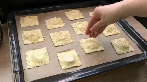 Gehobelte Mandeln werden auf die mit Ei bestrichenen Teigkissen gestreut