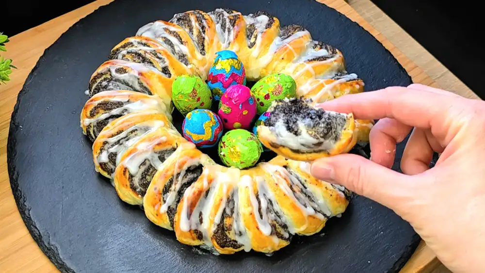 Detailansicht der saftigen Mohnfüllung und des weißen Zuckergusses auf einem Blätterteig-Kranz