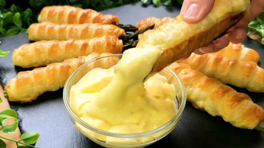 Detailansicht einer Blätterteig-Spargel-Stange mit Sauce Hollandaise als Dip