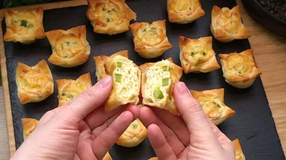 Detailansicht eines herzhaften Blätterteig-Häppchens mit grünem Spargel und geschmolzenem Käse