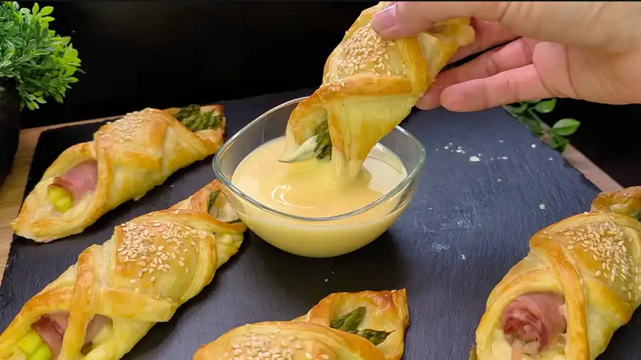 Detailansicht der Füllung aus grünem Spargel, Prosciutto und geschmolzenem Käse im Blätterteig