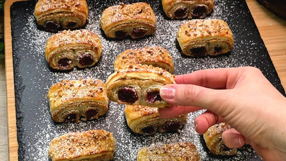 Detailansicht der saftigen Füllung aus Walnüssen und roten Kirschen im Blätterteig