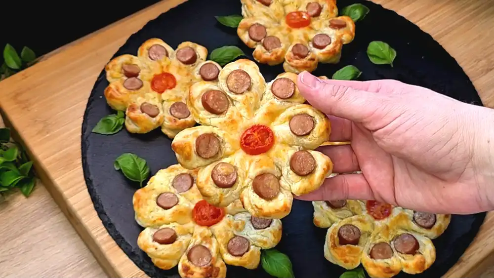 Detailansicht einer herzhaften Blätterteig-Blume mit geschmolzenem Käse im Kern