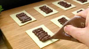 Nutella wird auf zugeschnittene Blätterteigstücke gestrichen