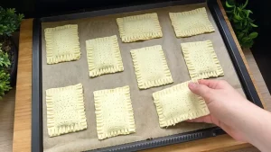 Rohe Nutella Blätterteig Taschen werden auf ein Backblech gelegt