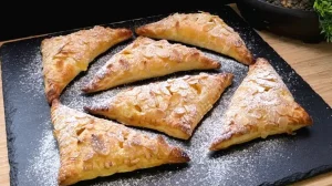 Goldbraun gebackene Pudding-Pfirsich-Dreiecke aus Blätterteig mit Mandeln