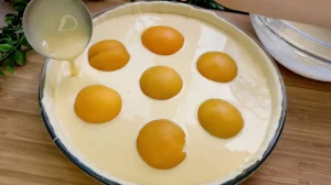 Cremige Quarkmasse wird vorsichtig über die Pfirsiche verteilt