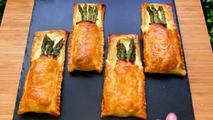 Goldbraun gebackene Blätterteigtaschen gefüllt mit grünem Spargel und Schinken