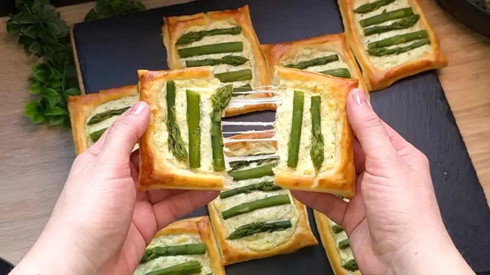Nahaufnahme von Blätterteig Snacks mit cremiger Käsefüllung und Spargel