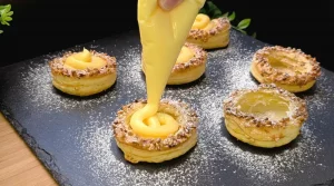 Gebackene Blätterteig Törtchen werden mit Vanillecreme gefüllt