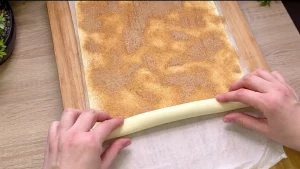 Zimt-Zucker wird gleichmäßig auf die mit Butter bestrichene Teigplatte gestreut