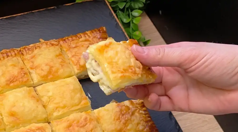 Detailansicht des Anschnitts mit sichtbaren Eischeiben, Schinken und geschmolzenem Käse.