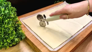 Der frische Blätterteig wird mit einem Messer in sechs gleichmäßige Dreiecke geschnitten