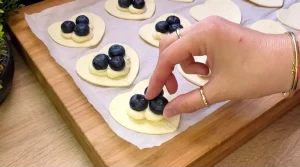 Frische Heidelbeeren werden auf die Vanille-Quark-Masse auf einem Teigherz platziert