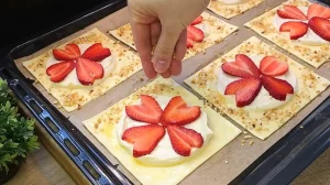 Gehackte Haselnüsse werden auf den mit Ei bestrichenen Rand der rohen Kuchen gestreut