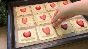 Gehobelte Mandeln werden auf die mit Ei bestrichenen Ränder der Mini-Kuchen gestreut