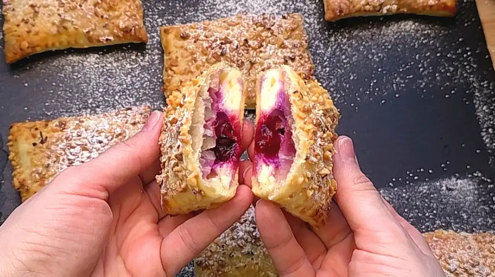 Detailansicht einer aufgebrochenen Blaubeer-Quark-Tasche mit flüssigem Beerenkern