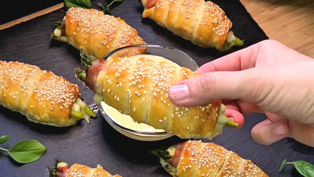 Detailansicht der knusprigen Blätterteig-Schichten mit geschmolzenem Käse und Spargel.