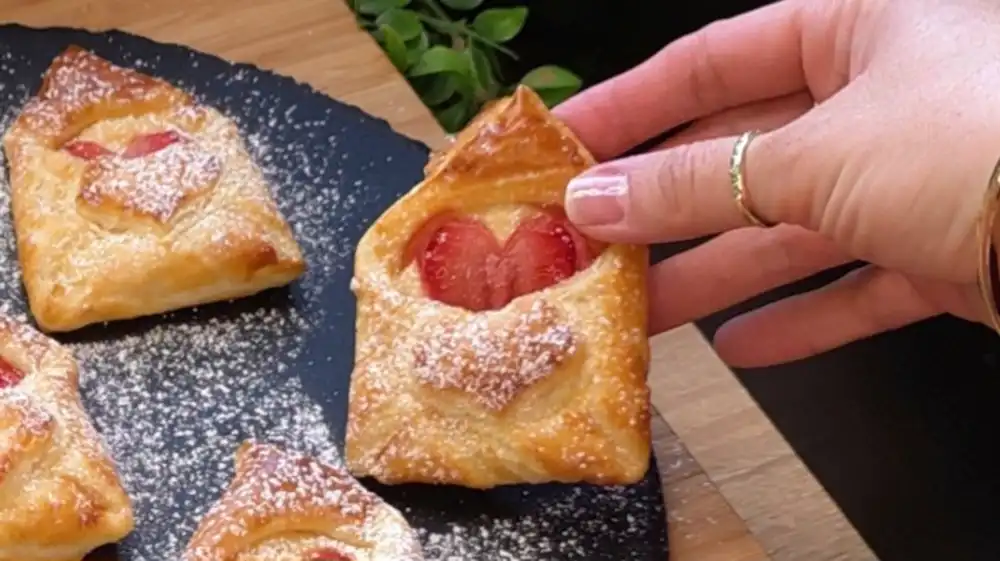 Detailansicht eines Blätterteig-Briefumschlags mit einer herzförmigen Erdbeere
