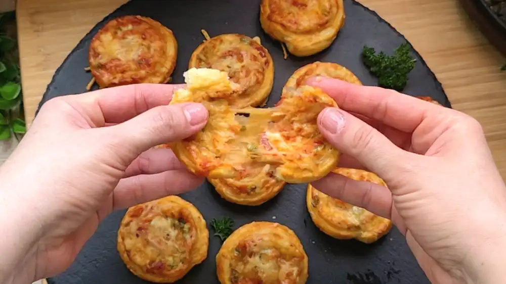 Detailansicht einer Pizzaschnecke mit sichtbarer Salami-Füllung und knusprigem Käserand.