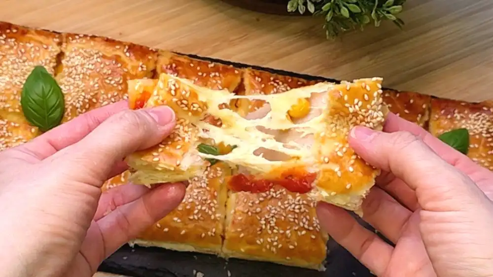 Detailansicht der Füllung aus geschmolzenem Käse, Hähnchen und Mais