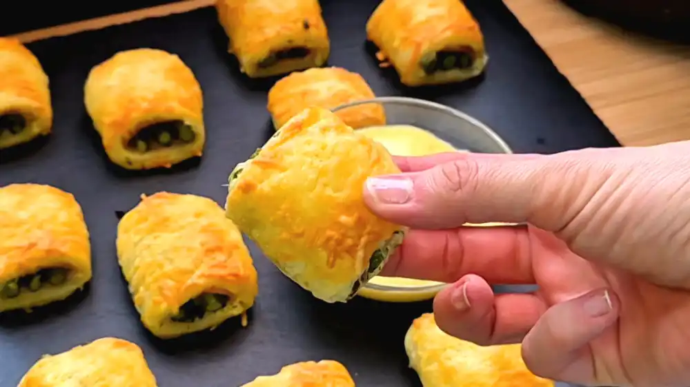 Detailansicht eines herzhaften Blätterteig-Häppchens mit grünem Spargel und Käsekruste.