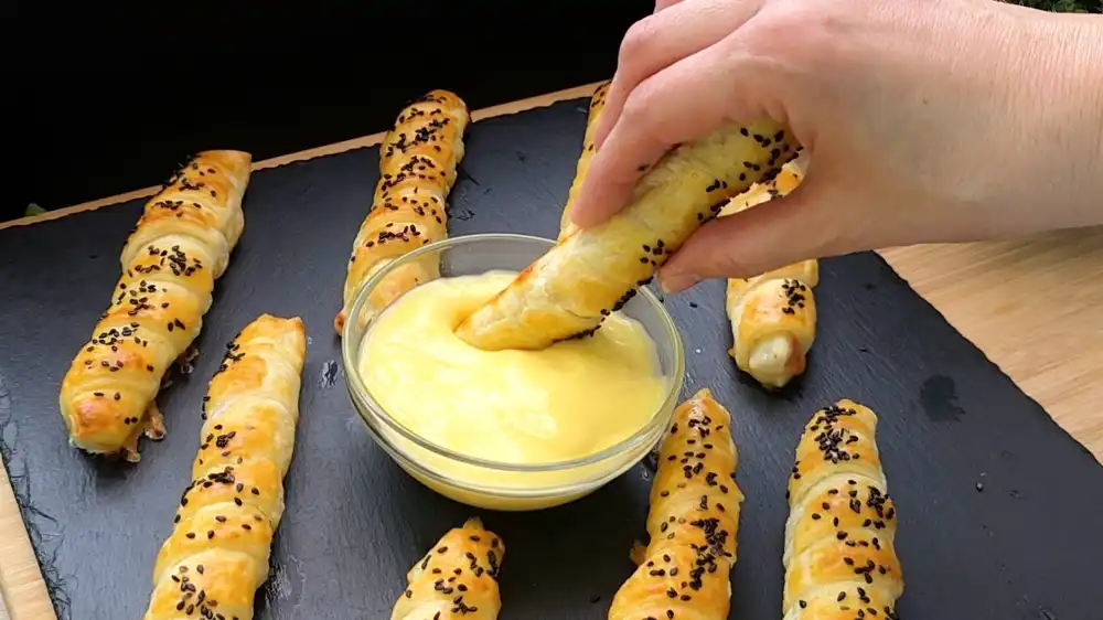Detailaufnahme einer aufgeschnittenen Spargelstange im knusprigen Teig mit Sauce Hollandaise.