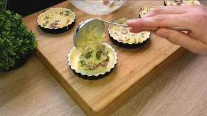 Blätterteig-Quadrate werden in eingefettete Mini-Pite-Formen gedrückt und angepasst.