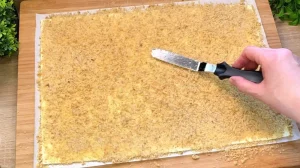 Gemahlene Walnüsse werden auf den mit Butter bestrichenen Blätterteig verteilt.